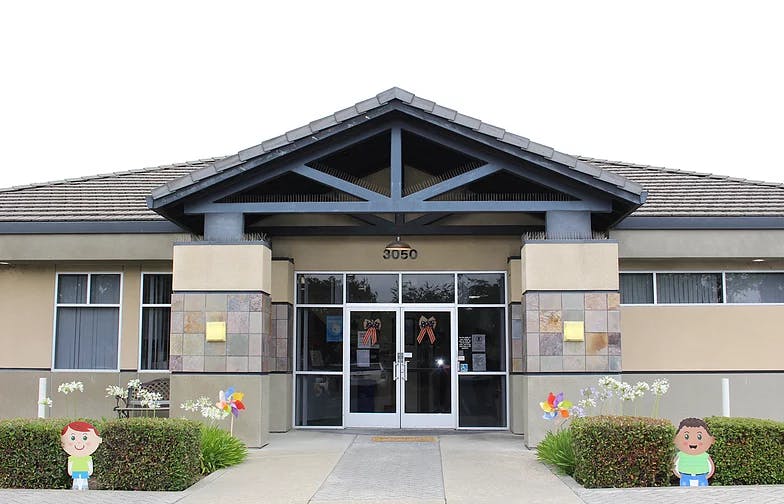 Front entrance of a building with glass doors and a peaked roof