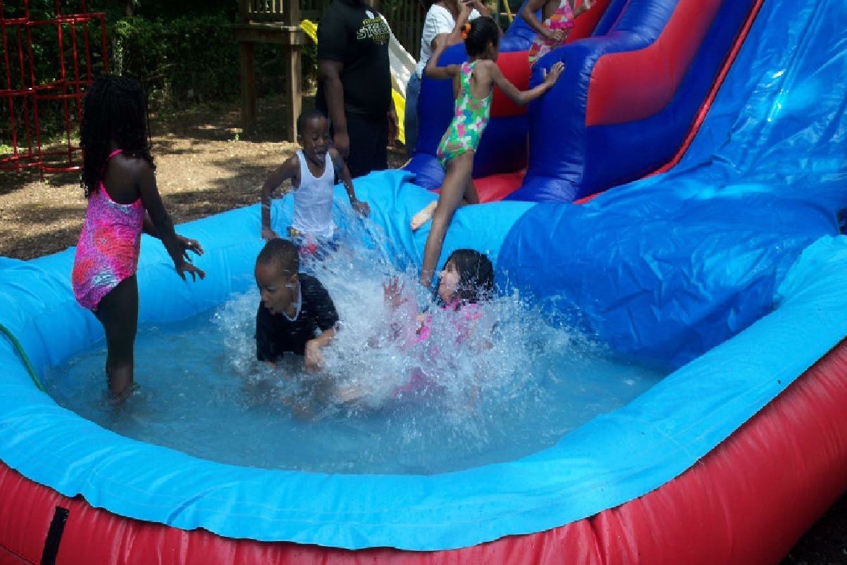 Children playing in an inflatable pool with a water slide