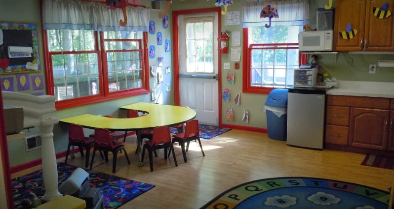 Classroom with a yellow U-shaped table and red chairs