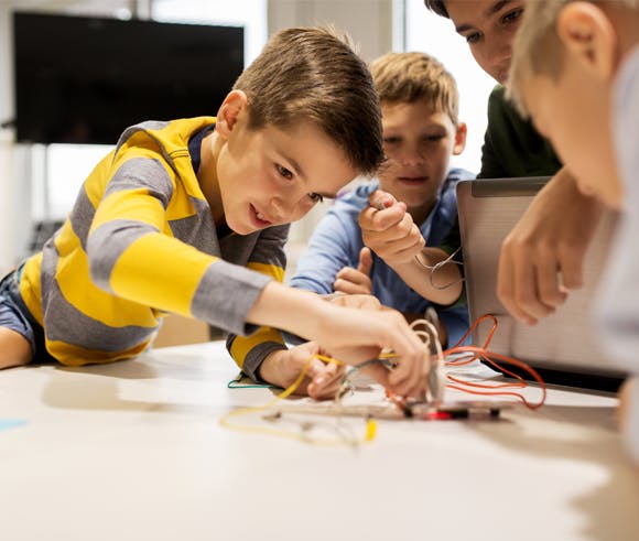 Children working on an electronics project with wires and components