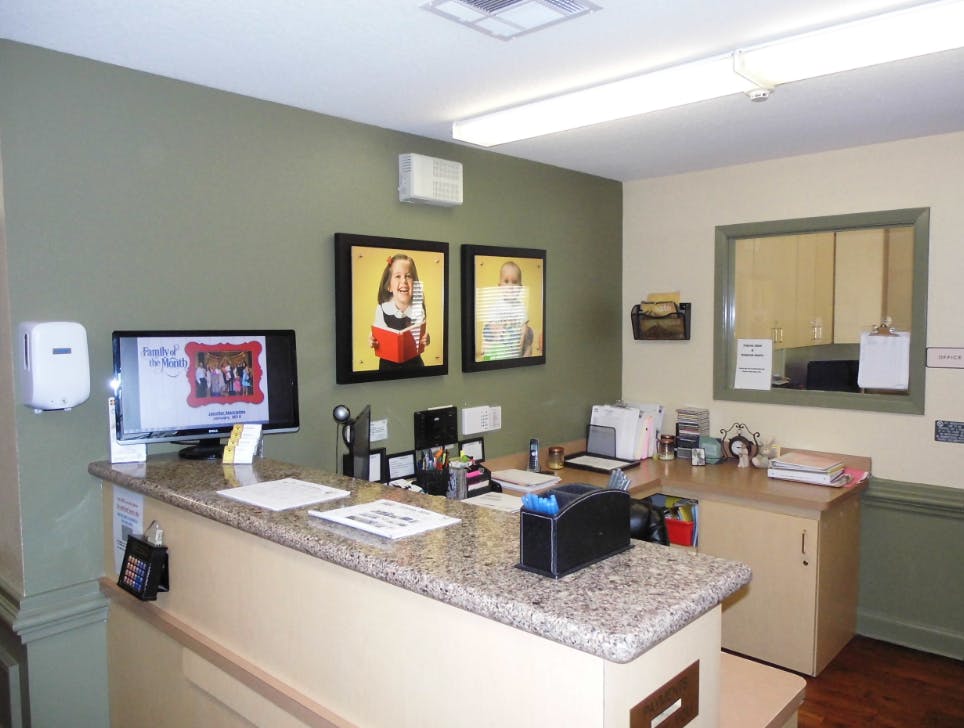 Reception desk with computer monitor and framed pictures on the wall