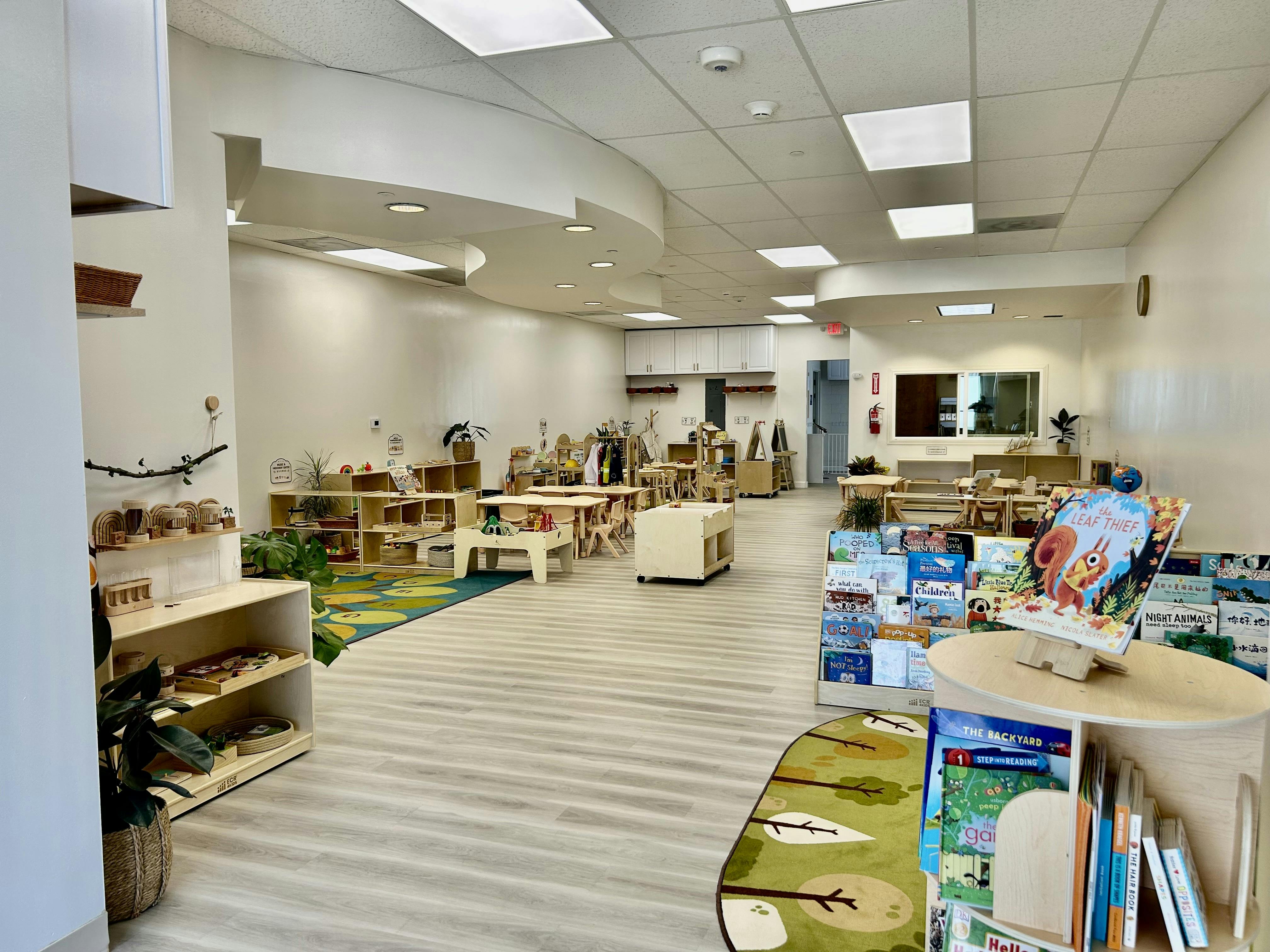 Spacious preschool classroom with organized shelves and children's books