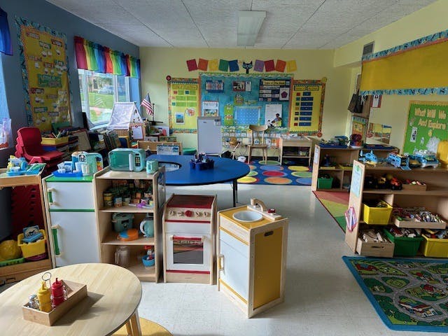 Playroom with toy kitchen, shelves, and tables