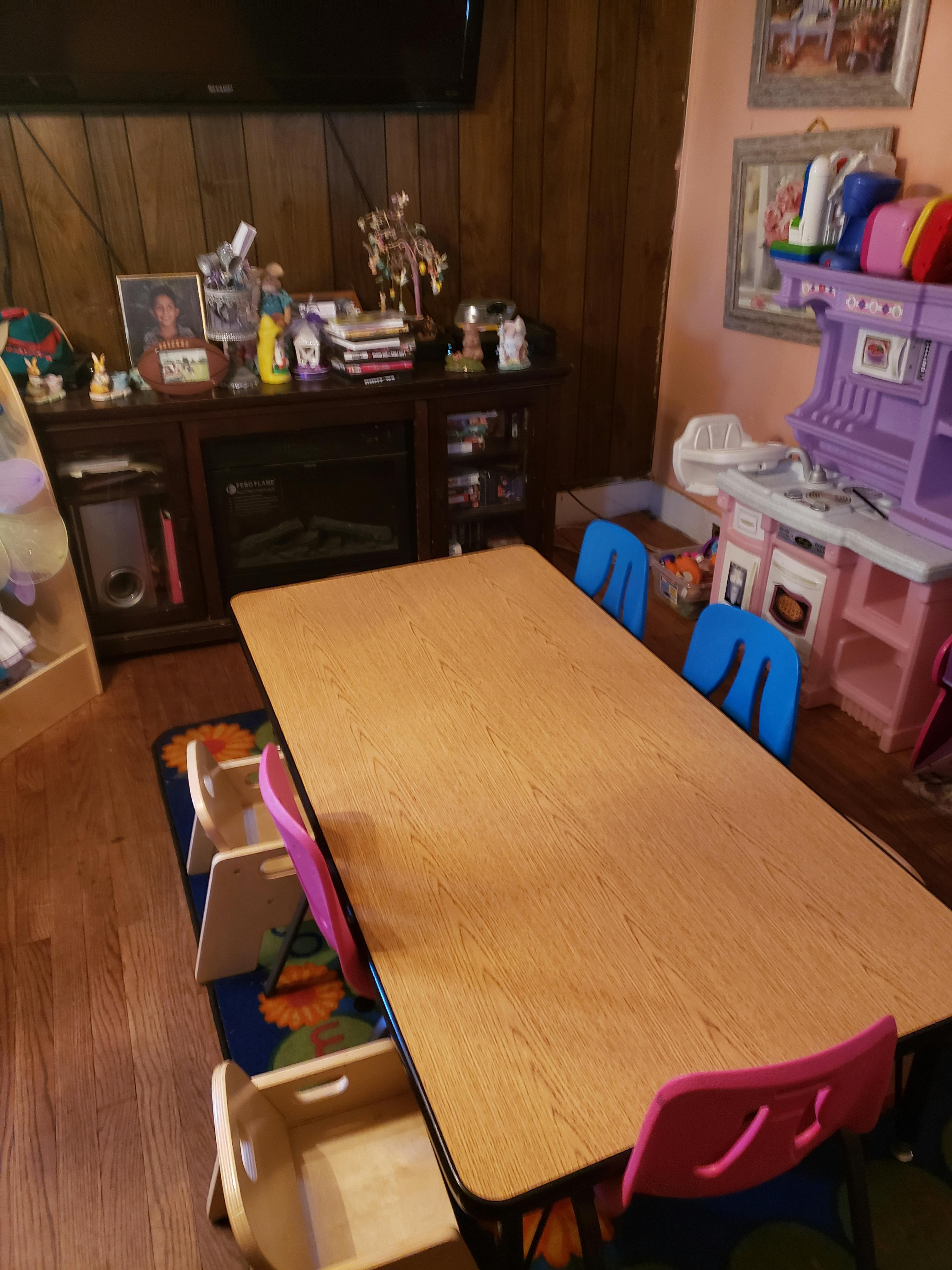 Long wooden table with several small chairs around it