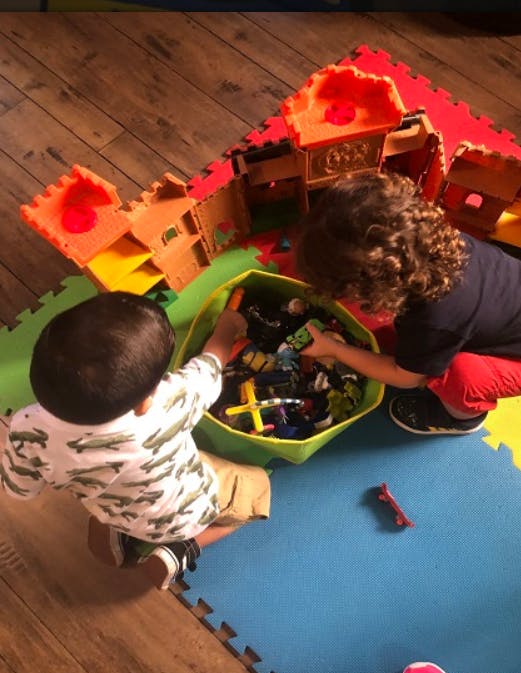 Two children playing with toys in a bin