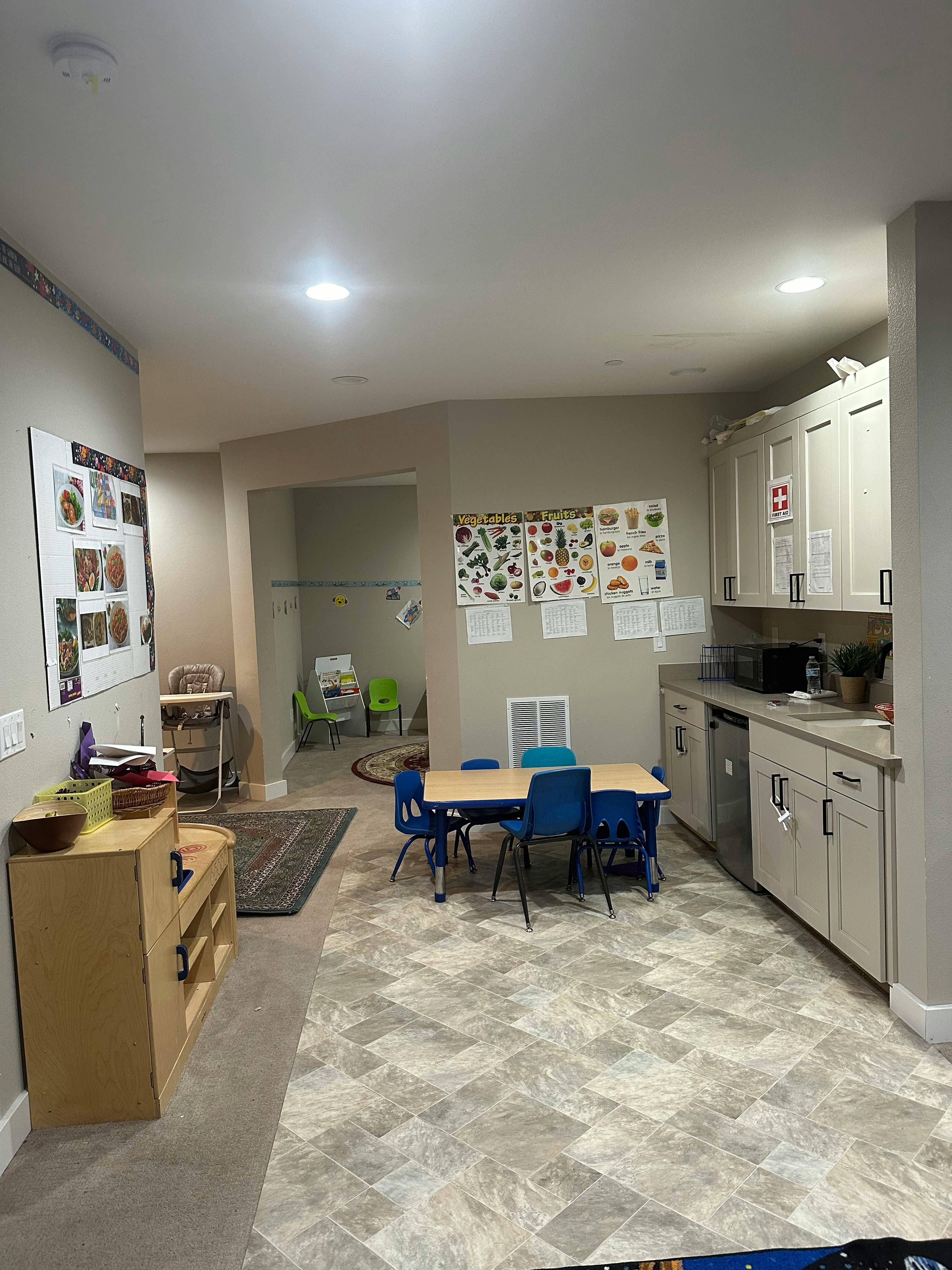 Classroom with small table and chairs, kitchen area, and bulletin boards