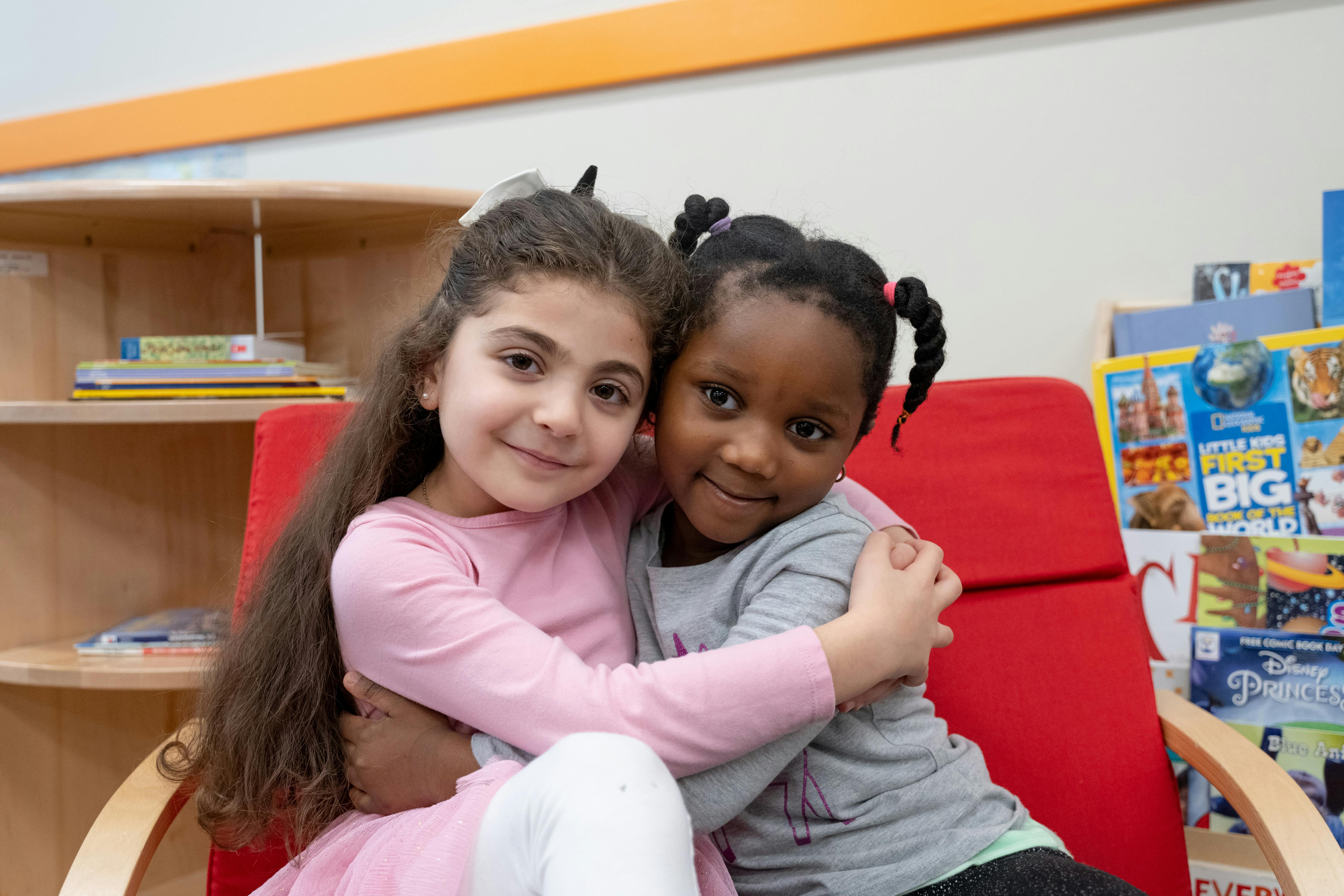 Two children hugging in a classroom