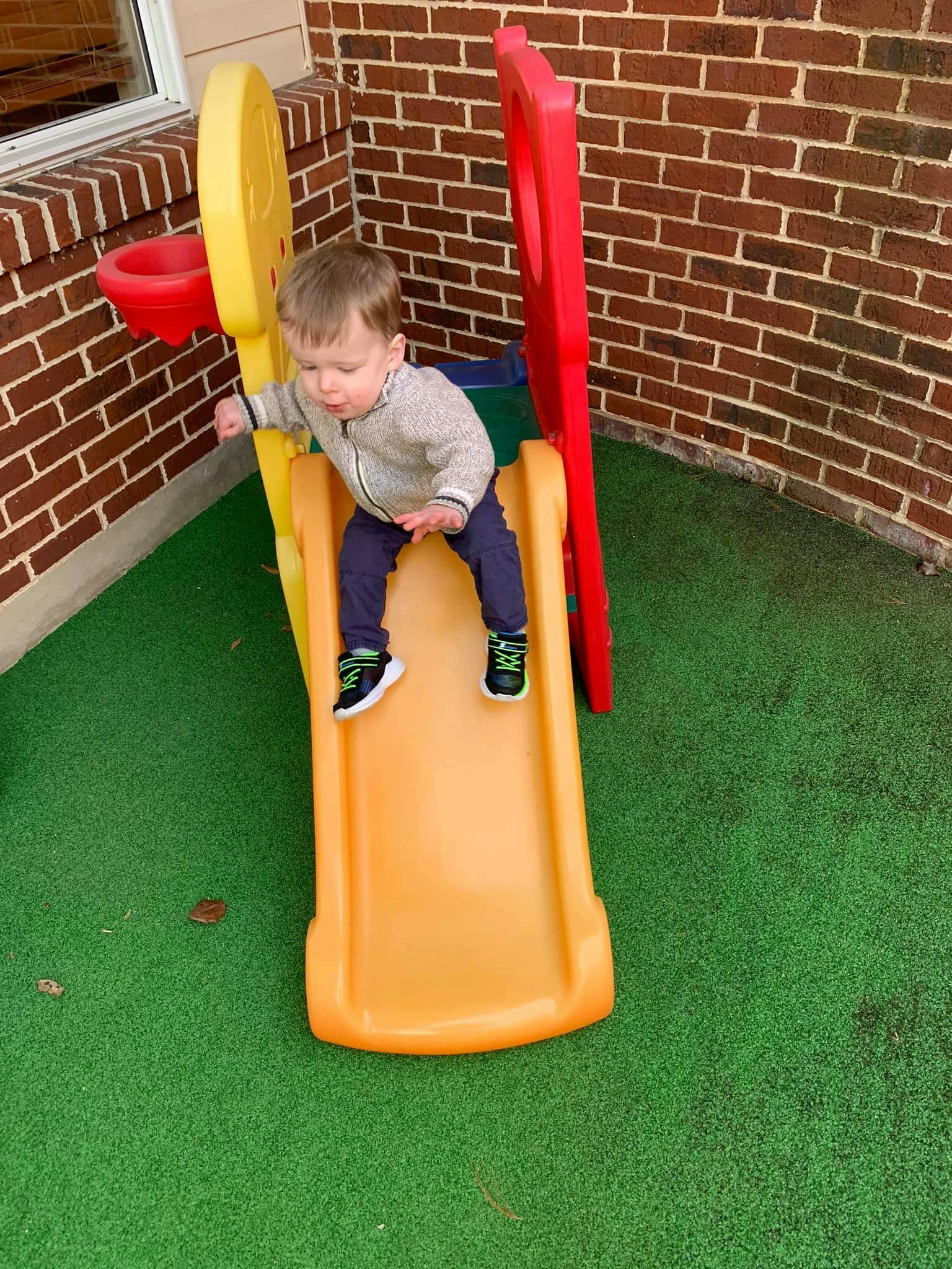 Child on a small orange slide