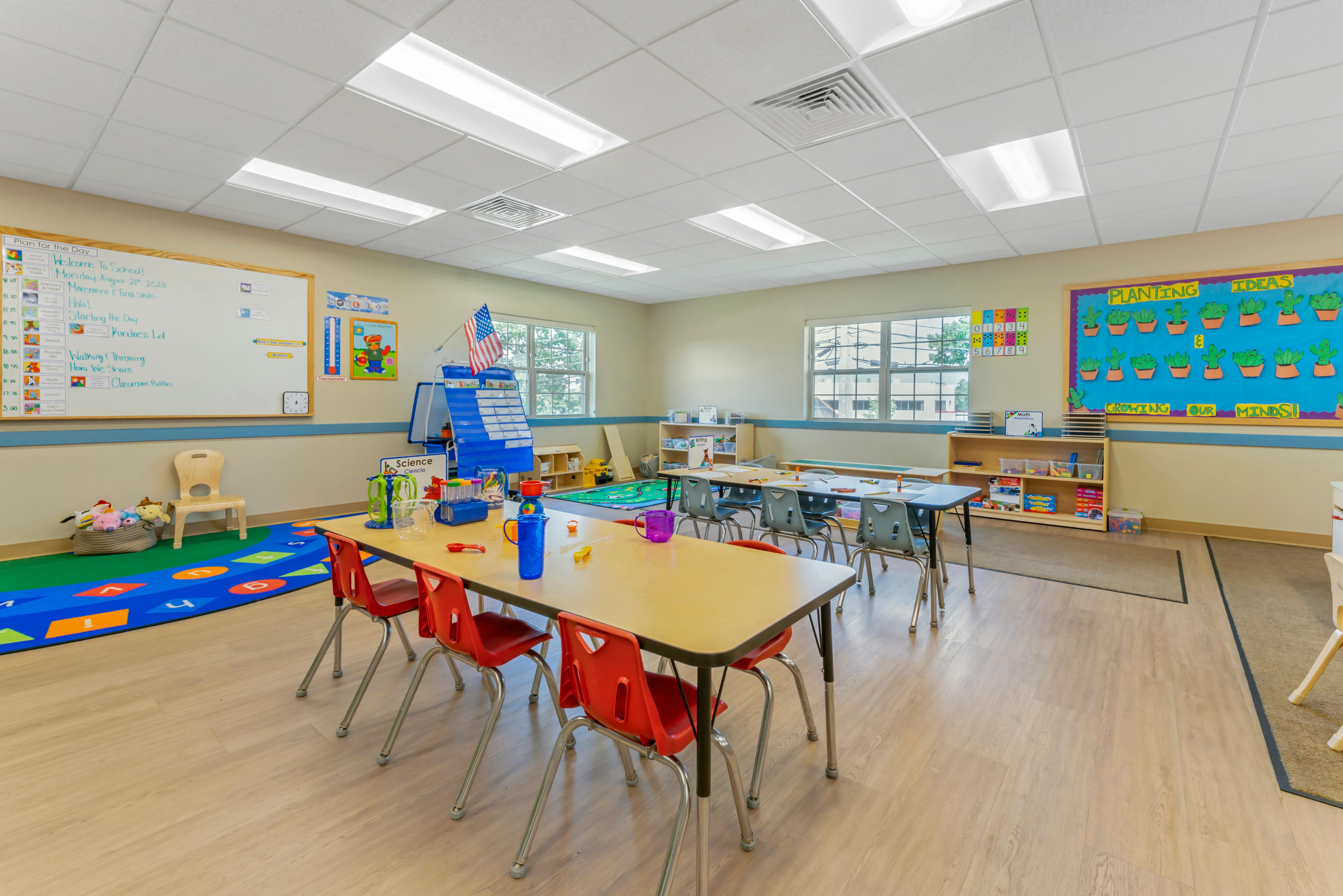 An empty classroom with light wood floors and colorful learning materials