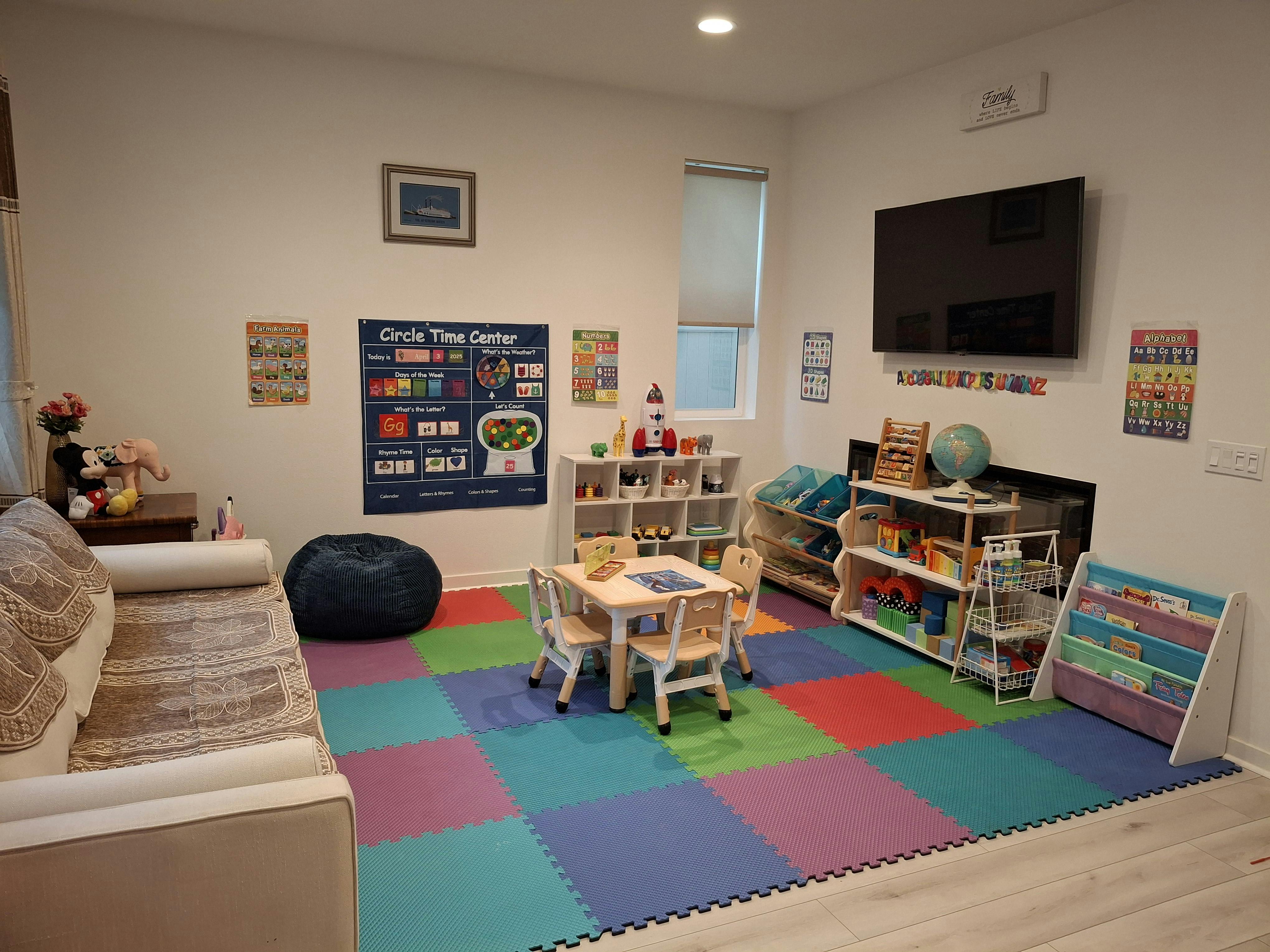 Playroom with colorful floor mats, small table and chairs, and shelves with shelves of toys