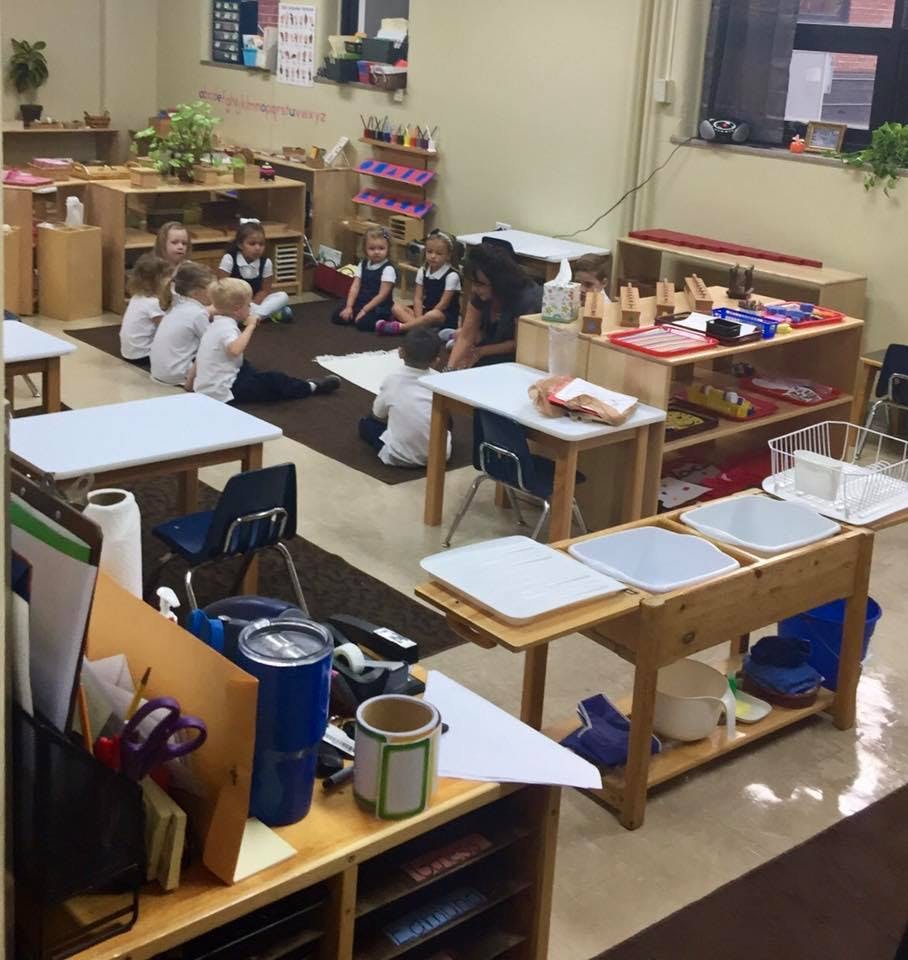 Children sitting on a rug in a classroom