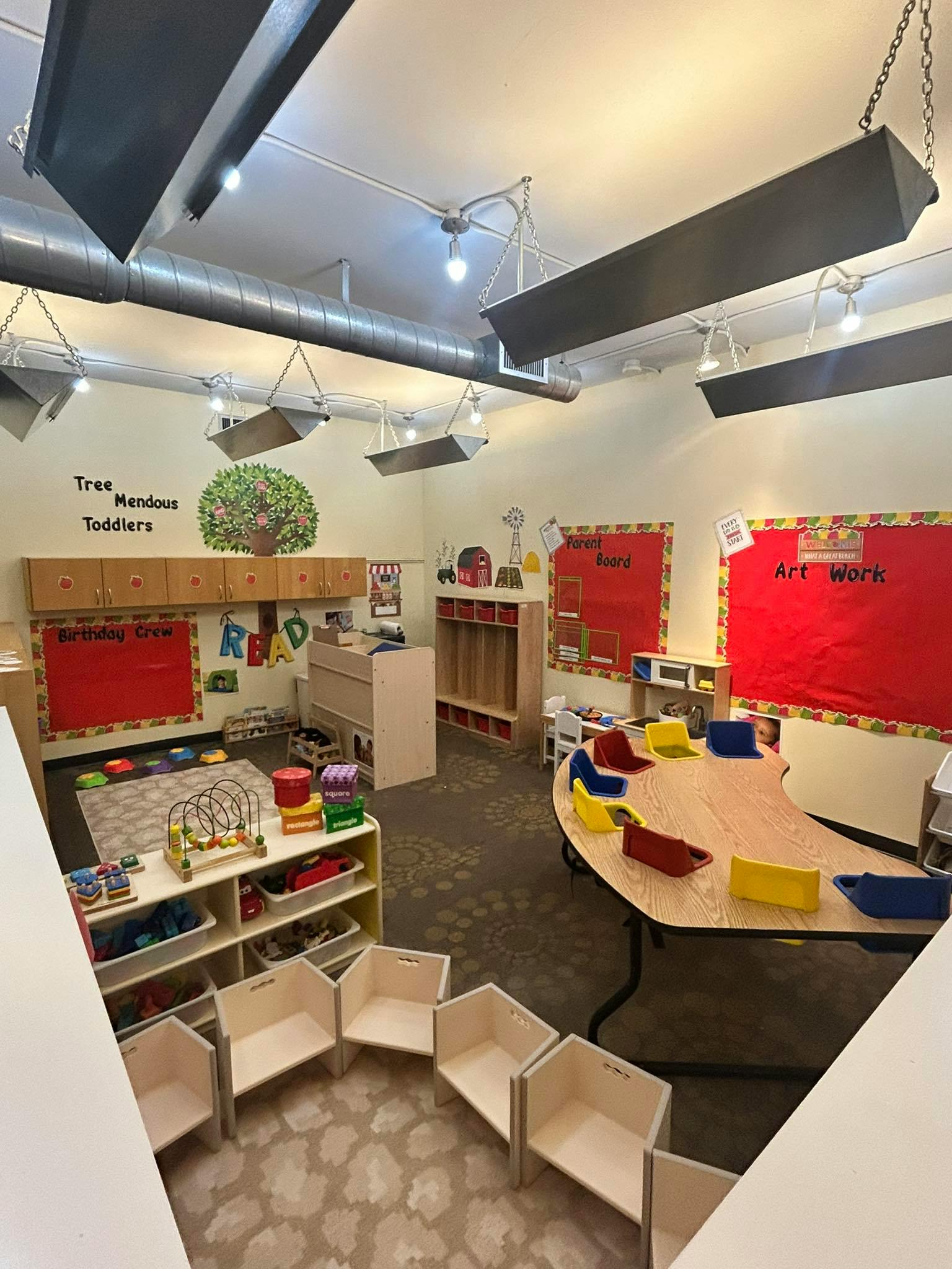 Children's classroom with small tables, chairs, and learning decorations