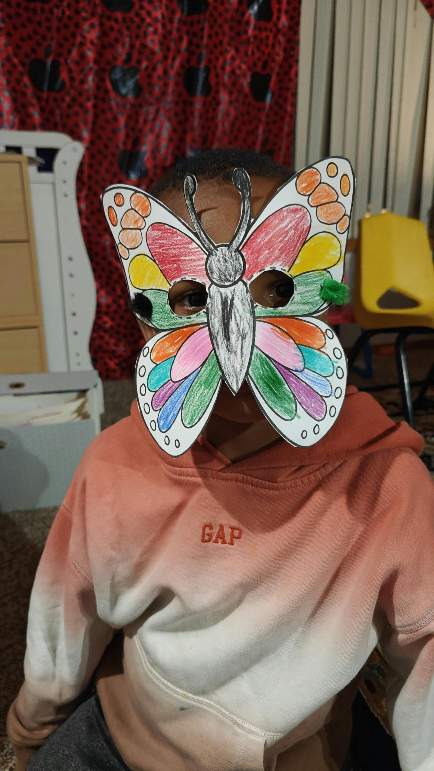 Child wearing a colorful butterfly mask