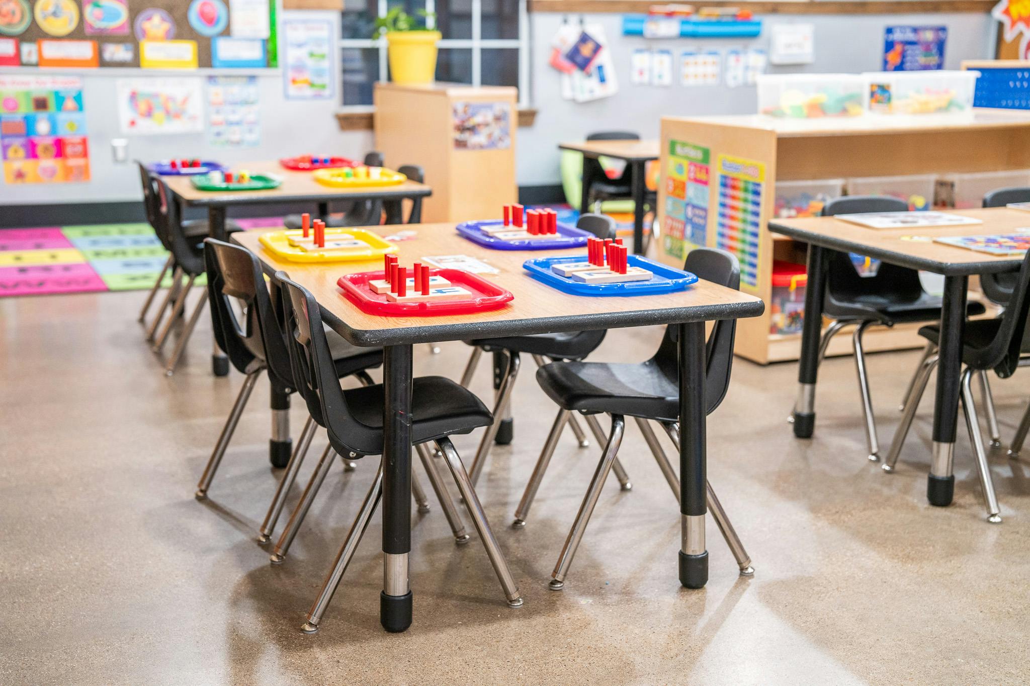 Classroom tables with counting activities on colored trays
