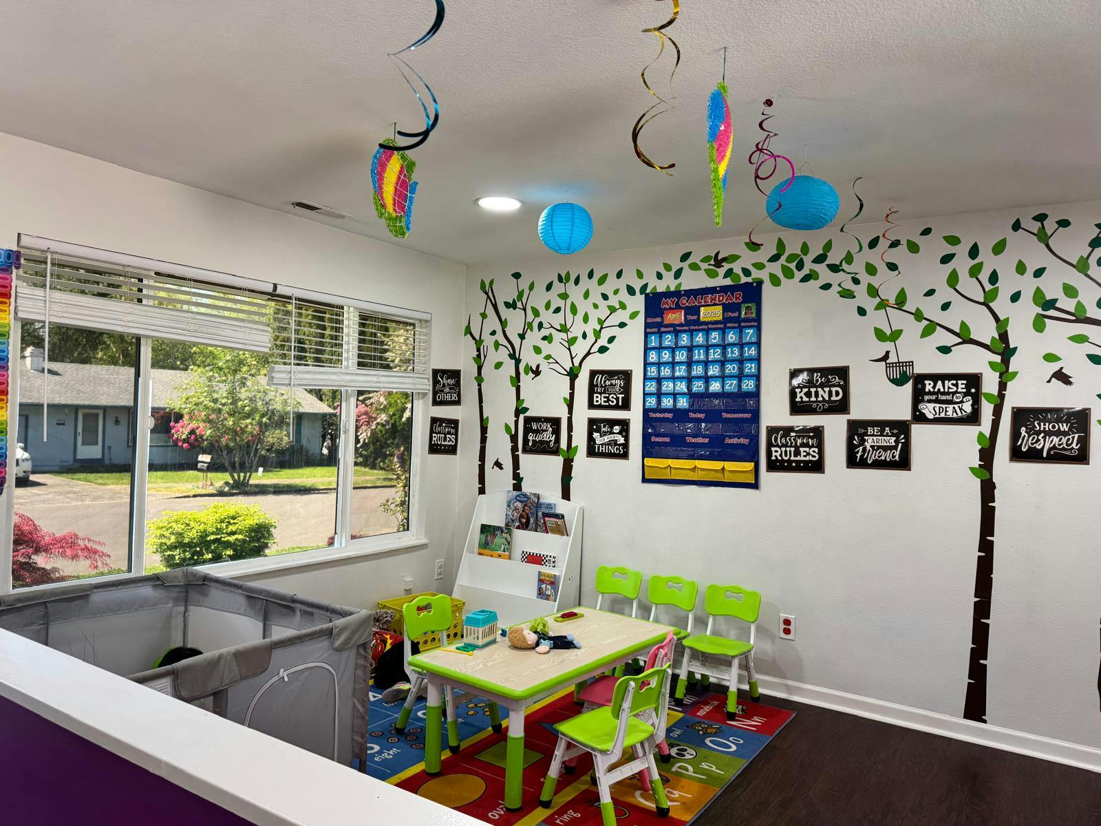 Playroom with small table and chairs, wall decals, and a window