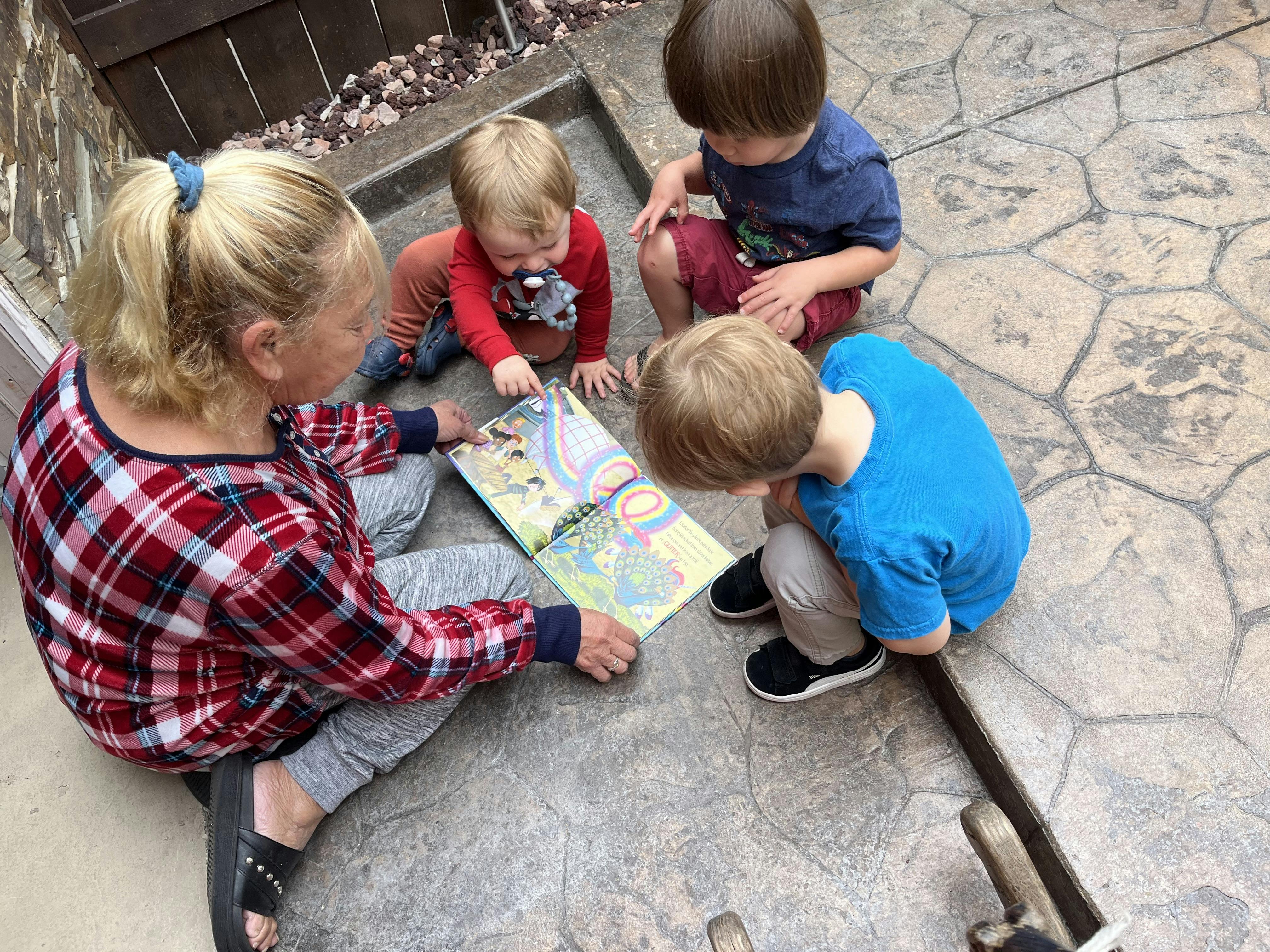 Adult and three children looking at a book together