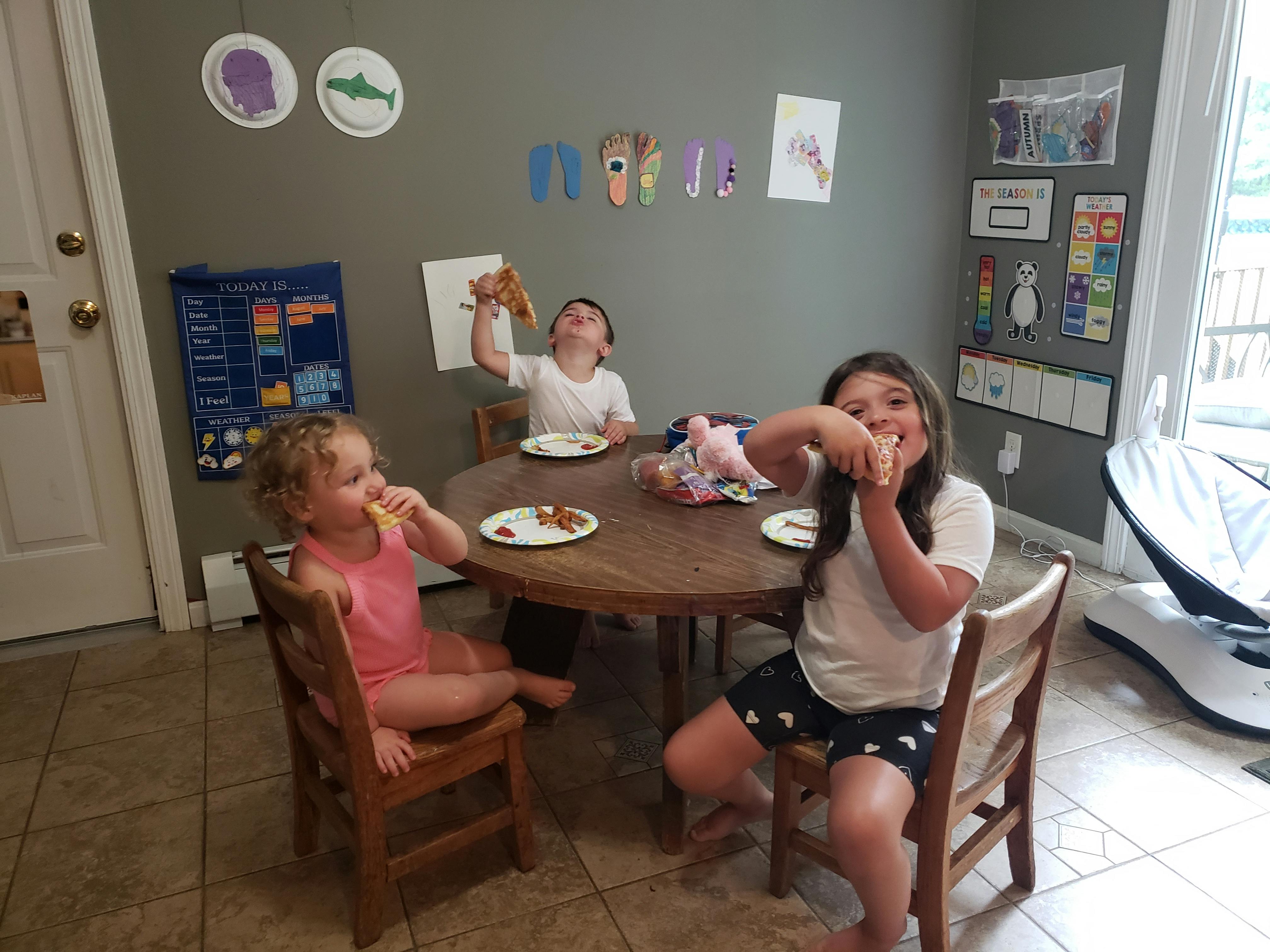 Three children eating at a round table