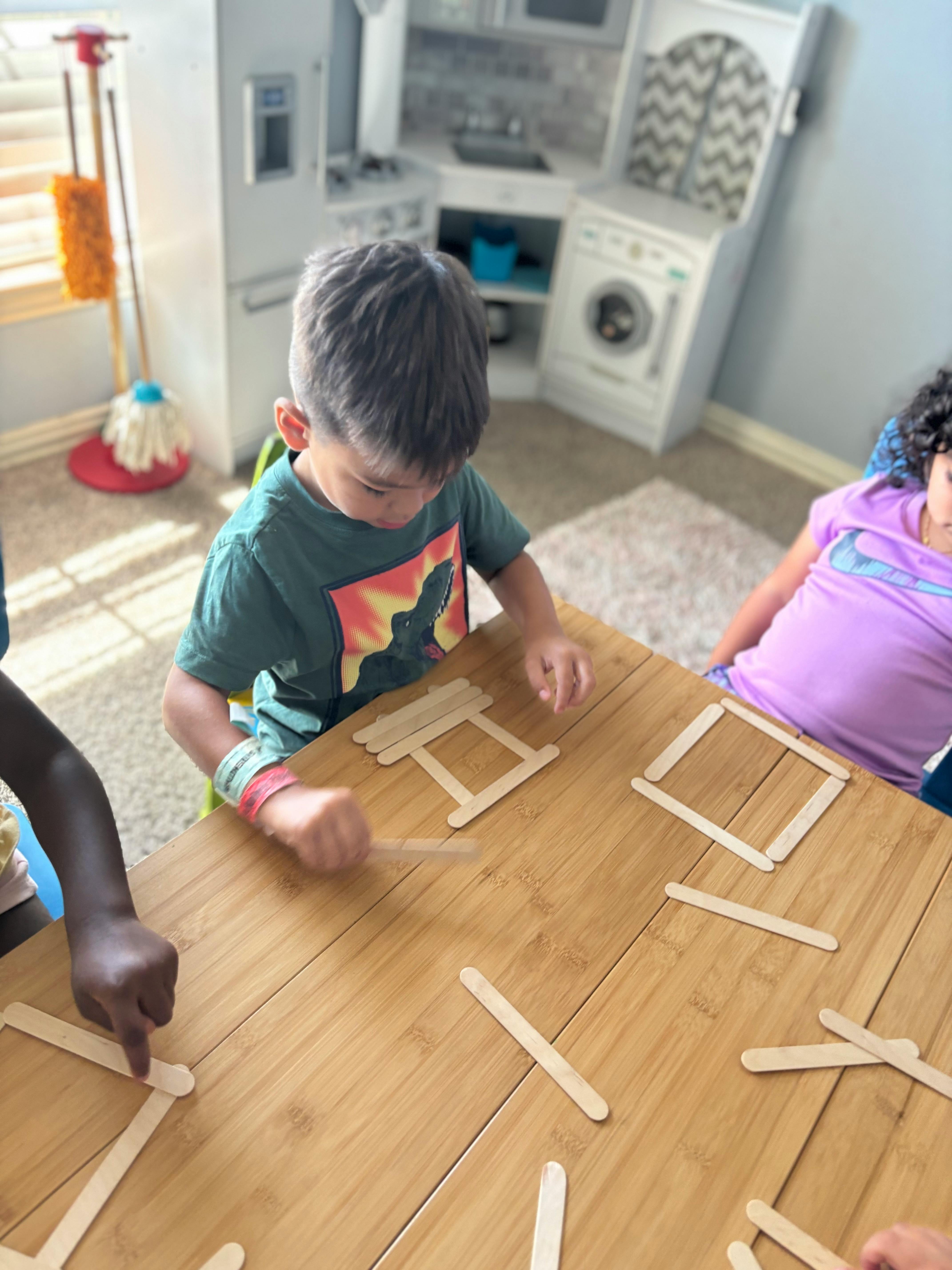 Child playing with craft sticks at a table