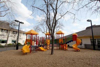 Empty playground with yellow and red equipment on wood chips