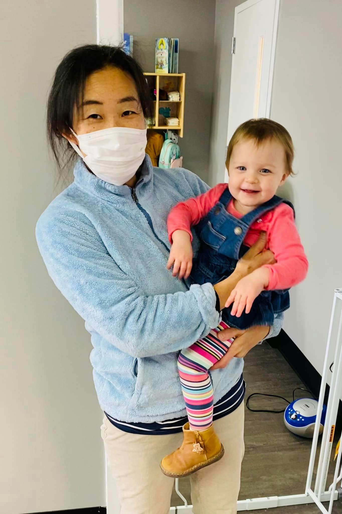 Person in mask holding a child
