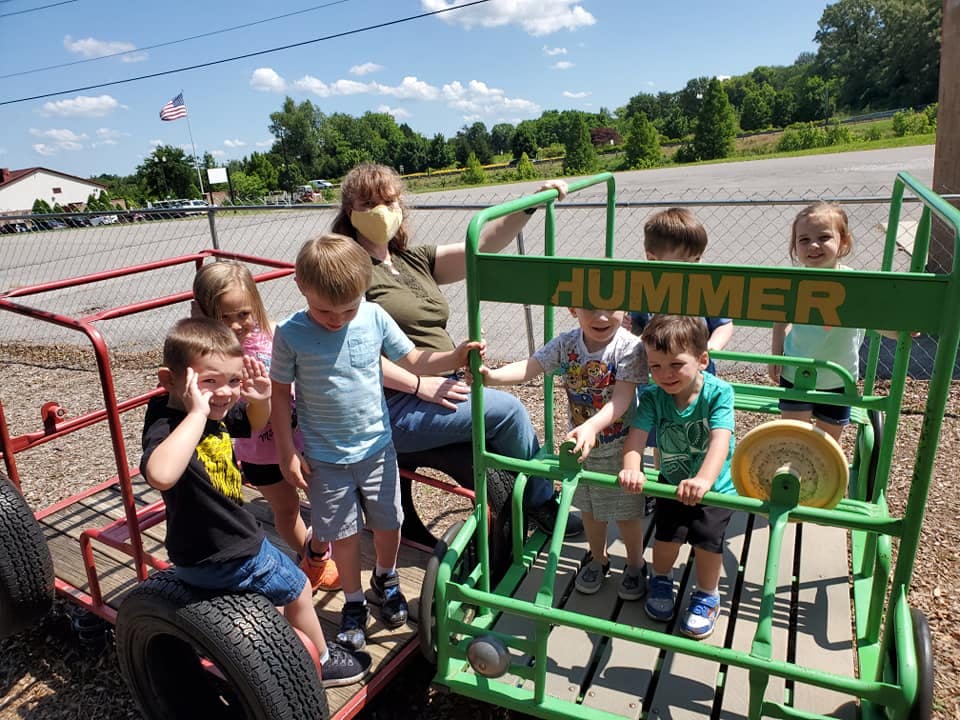 Adult and children playing on outdoor equipment with "HUMMER" text