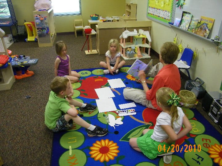 Adult reading to children in a classroom