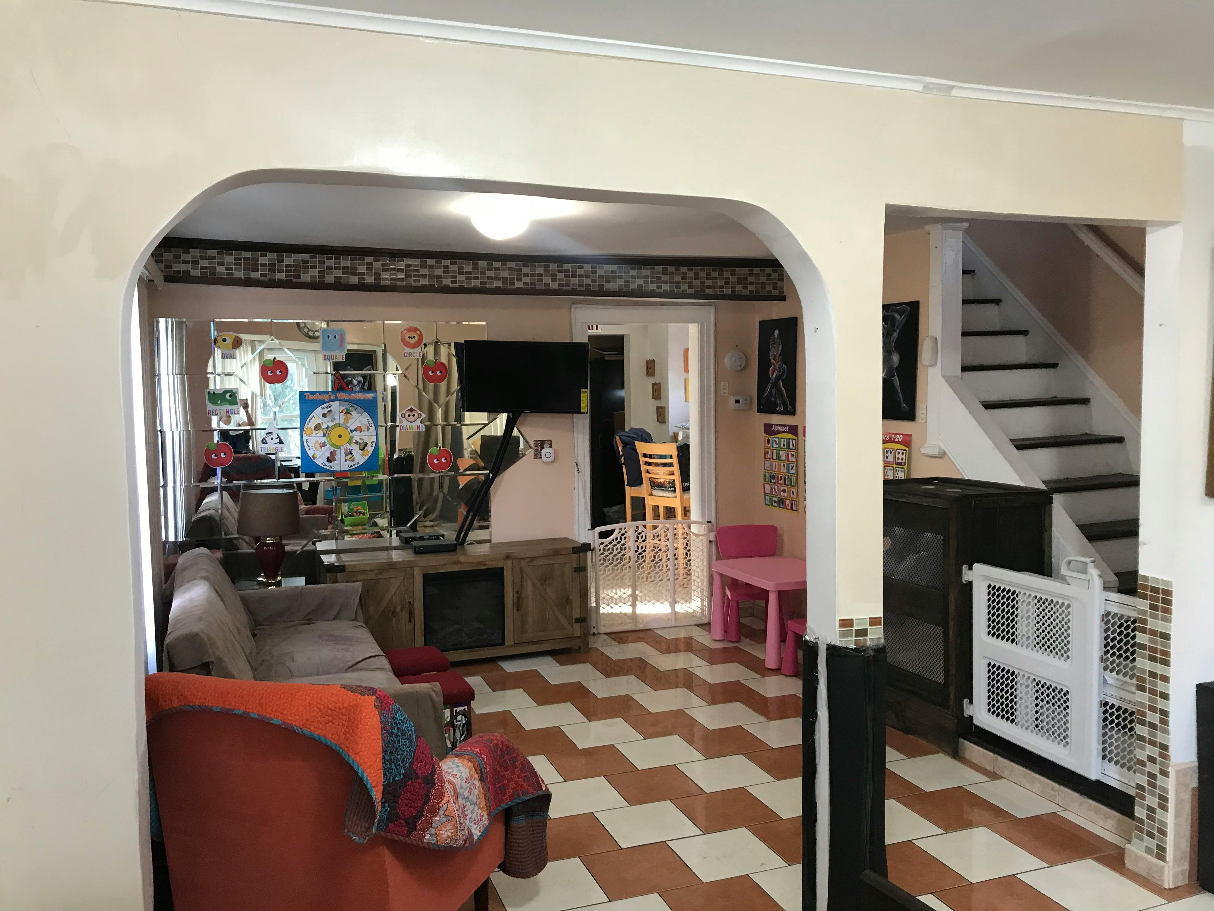 Living room with a sofa, TV, and a staircase with a baby gate