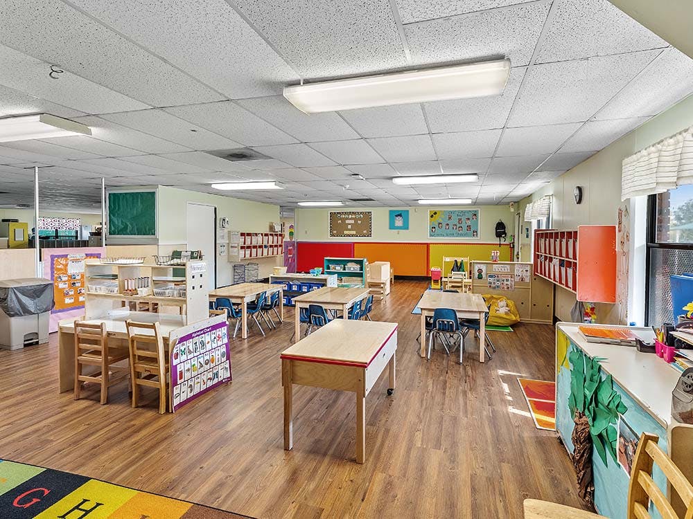 Classroom with tables, chairs, and learning decorations