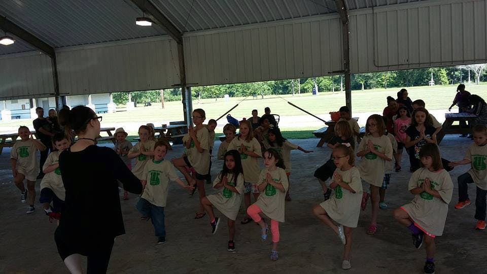 Person leading a group of children in an exercise class oragnized activity