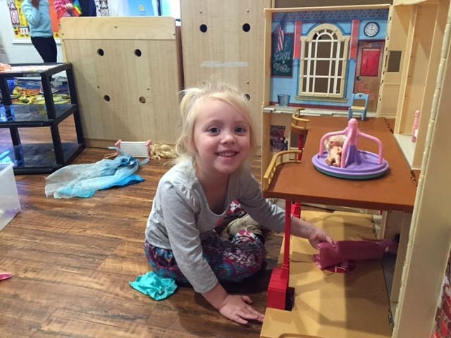 Child playing with a dollhouse