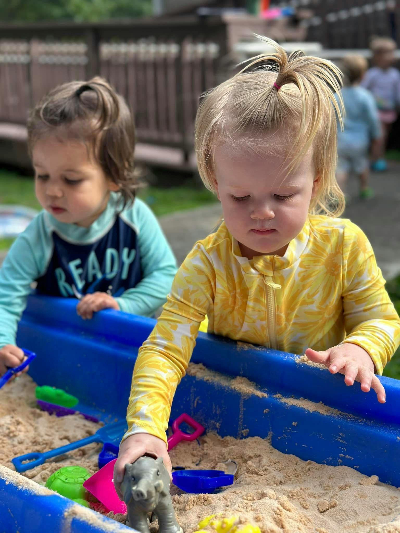 Two children playing in a sandbox