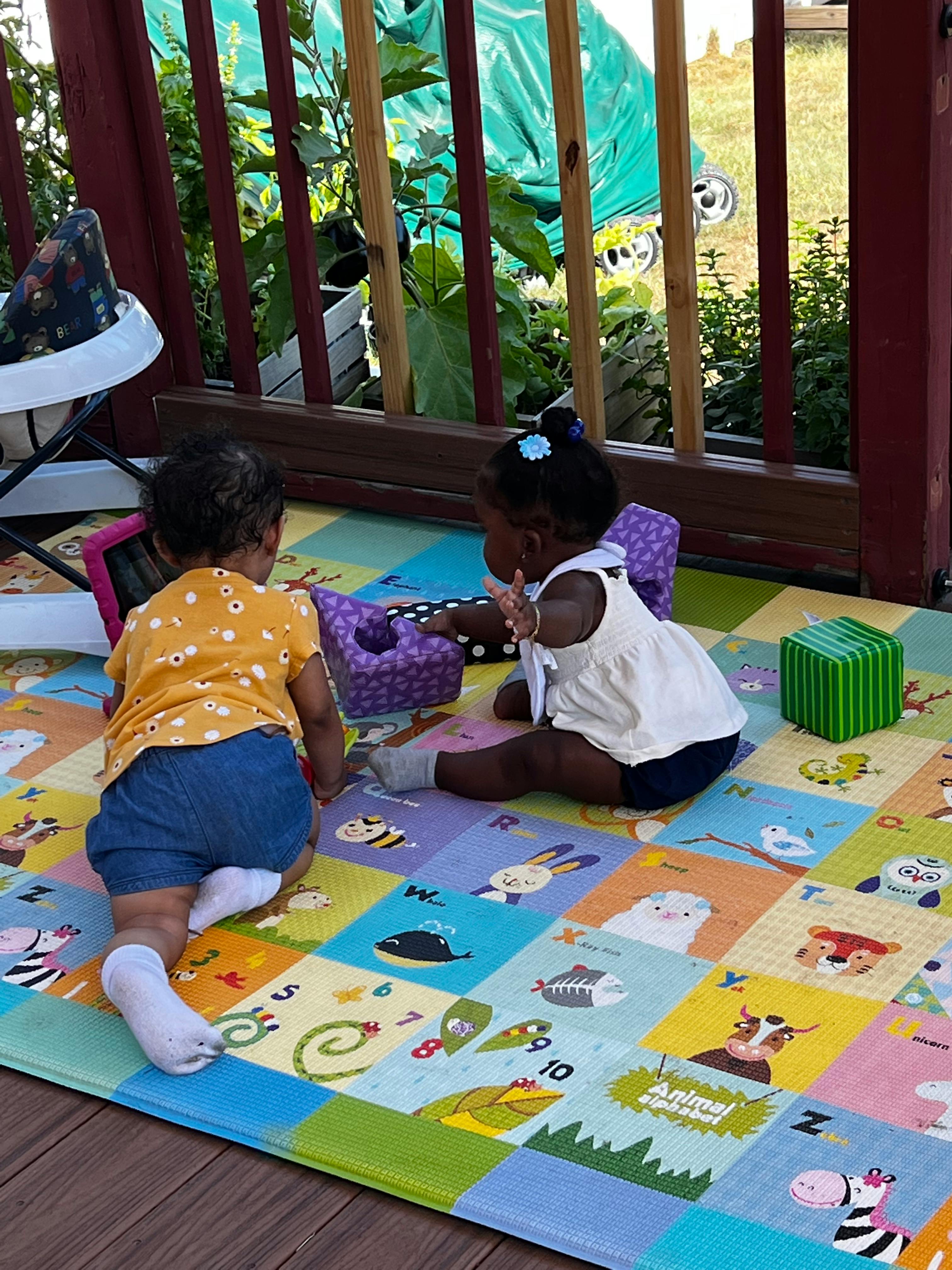 Two children playing on a colorful mat