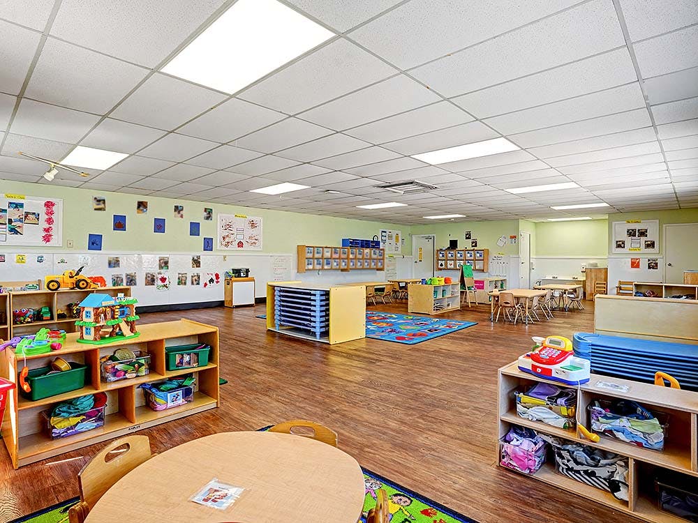 Empty colorful preschool classroom with toys and small tables