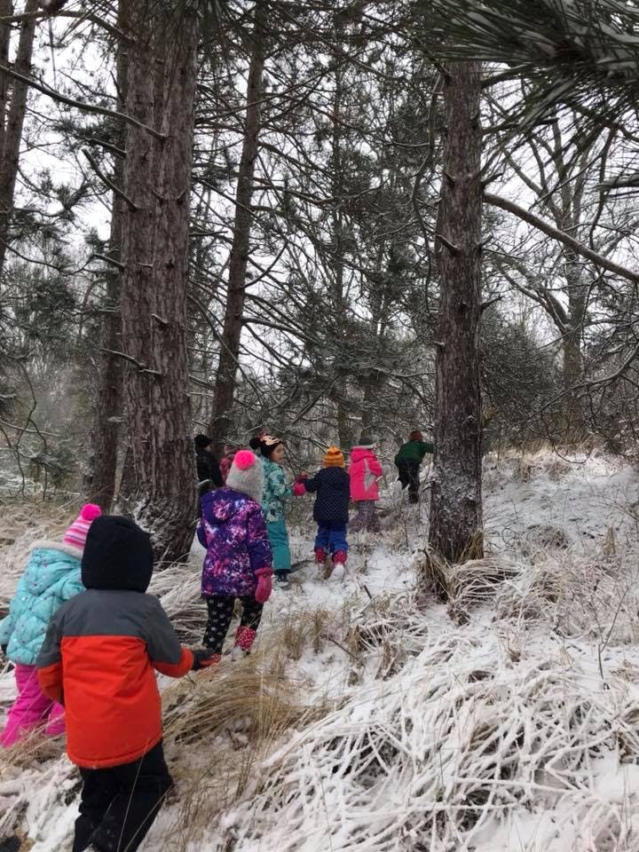 Children walking through a snowy forest