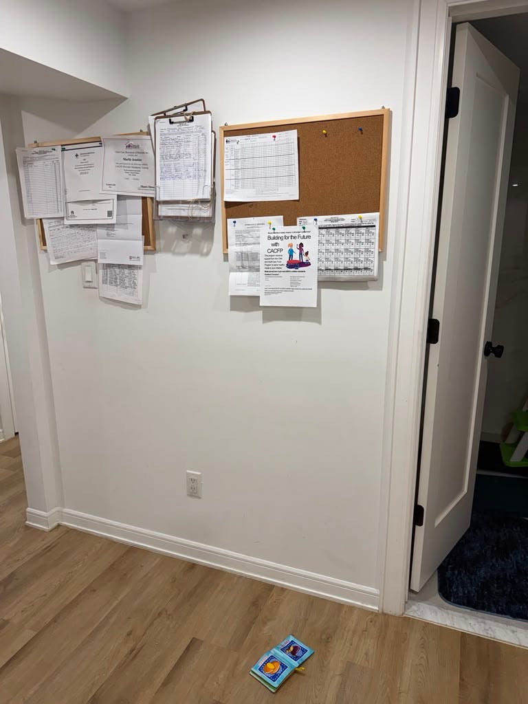 Cork boards with posted documents and informational flyers on a white wall