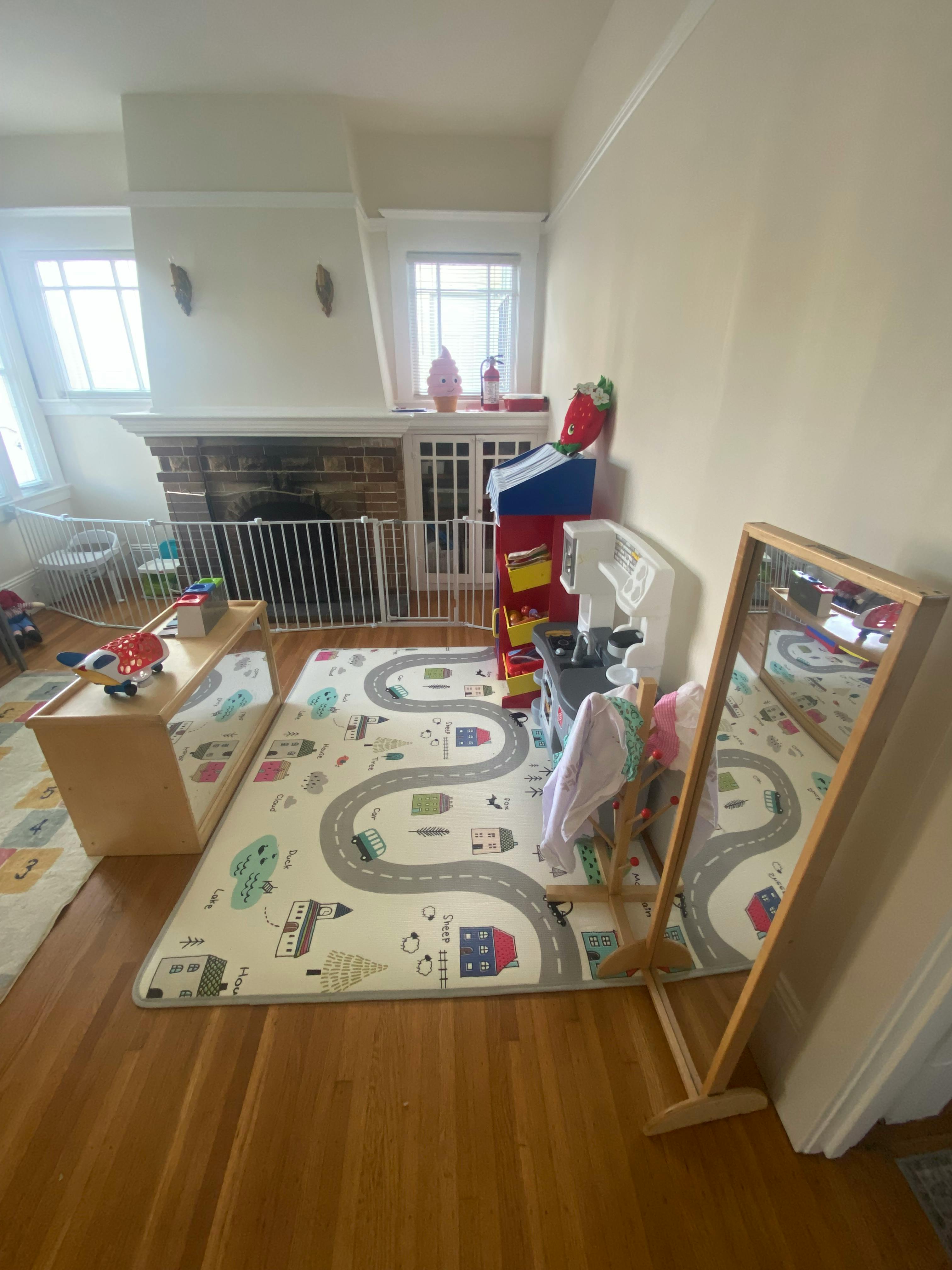 Playroom with a road map rug, wooden table, and standing mirror