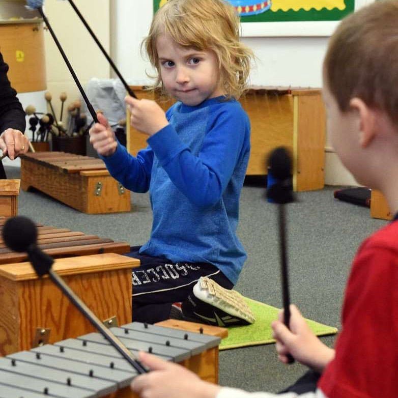 Child playing a xylophone with mallets