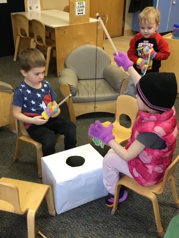 Children playing with a fishing game