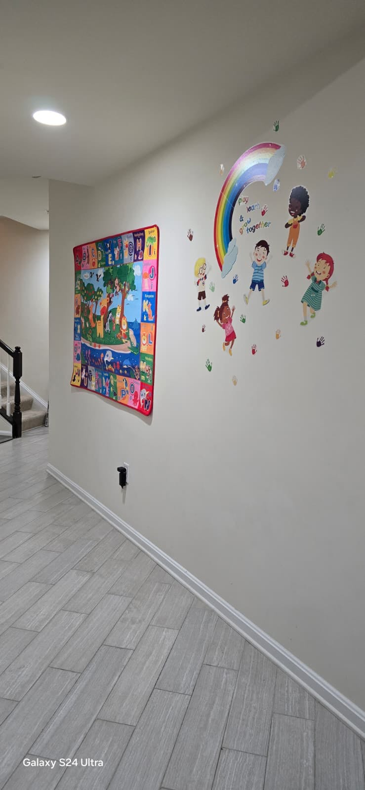 Wall decorations with alphabet chart and rainbow with diverse children cutouts
