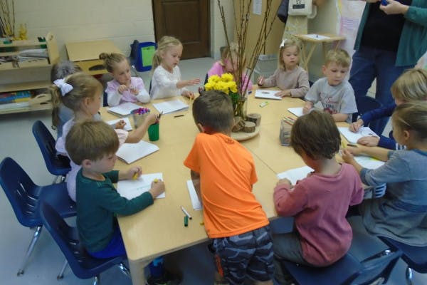 Children sitting around a table drawing