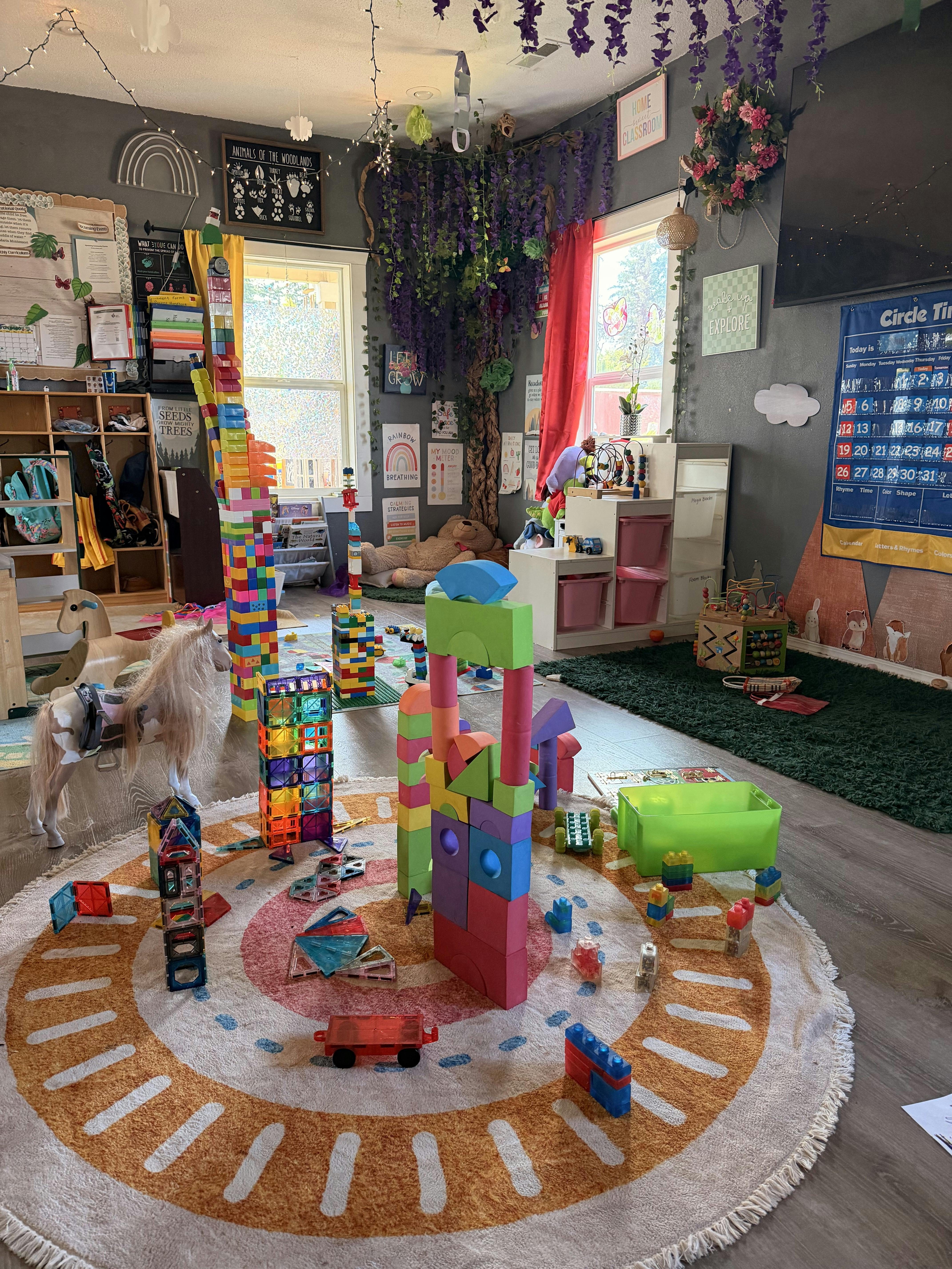 Colorful toy building blocks and magnetic tiles arranged on a circular rug