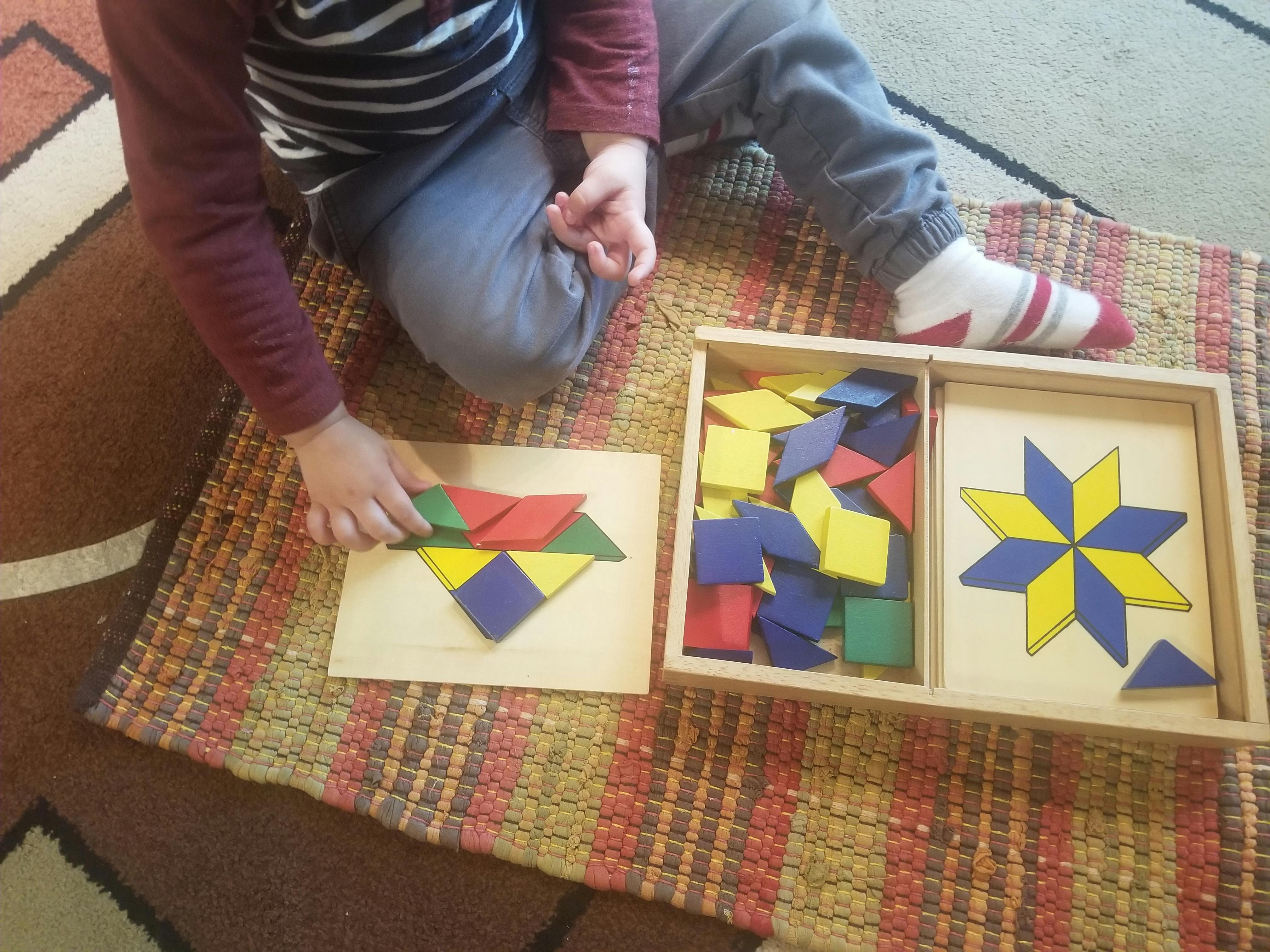 Child playing with colorful geometric shape puzzle pieces