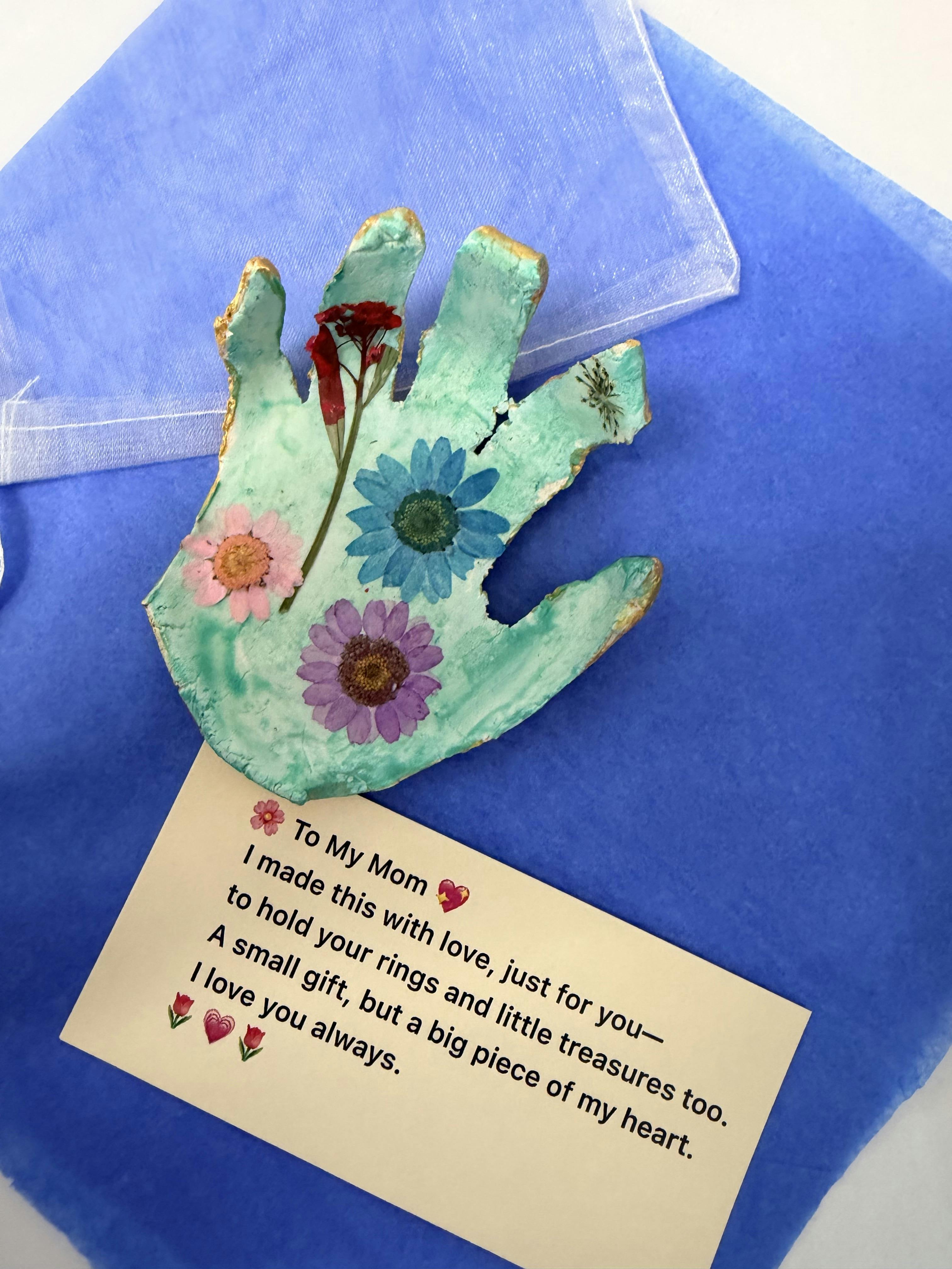 A hand-shaped tray with pressed flowers and a card that reads "To My Mom"