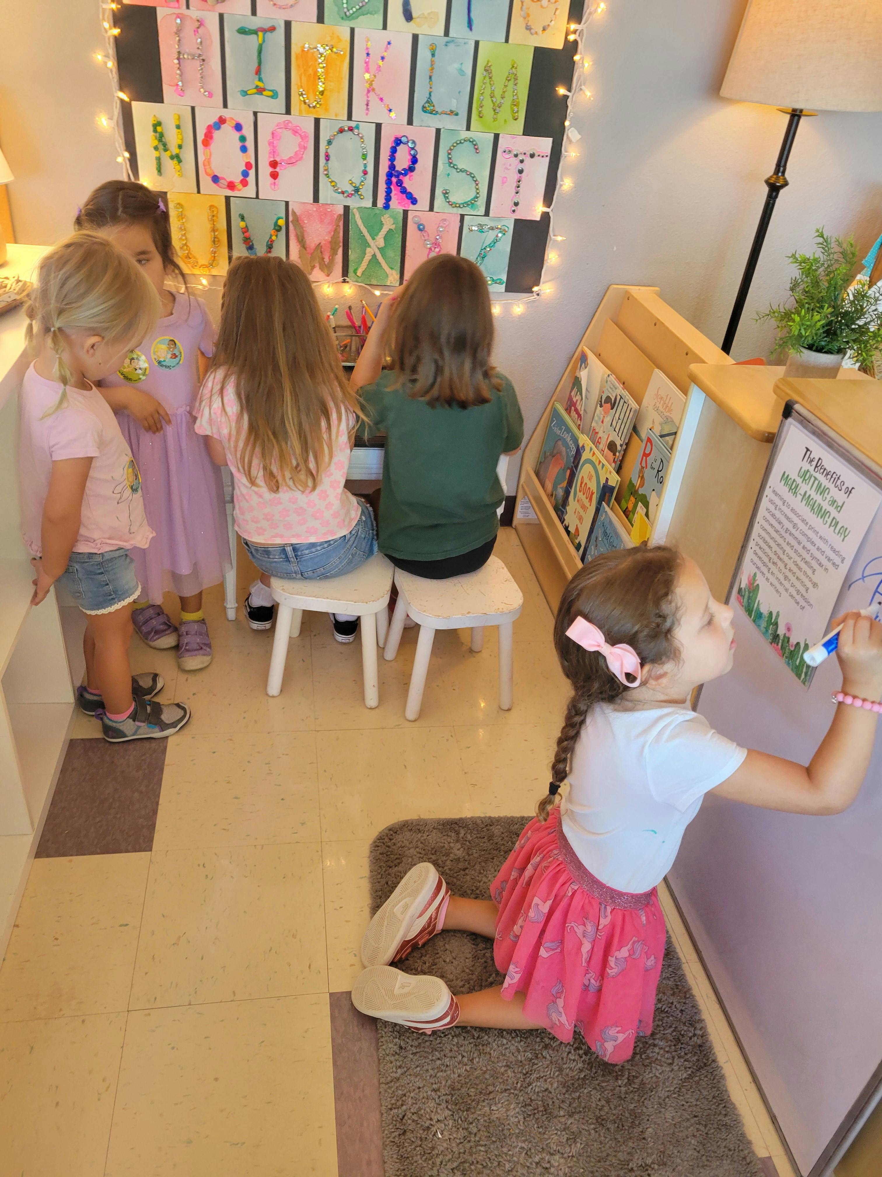 Children in a classroom, one child writing on a whiteboard