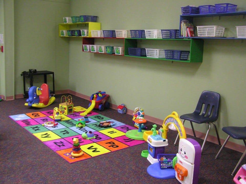 Playroom with alphabet rug and various toys