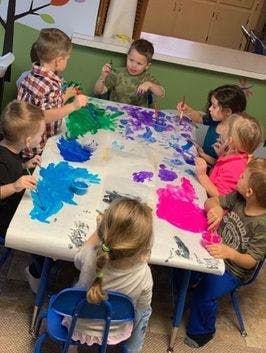 Children painting on a large sheet of paper