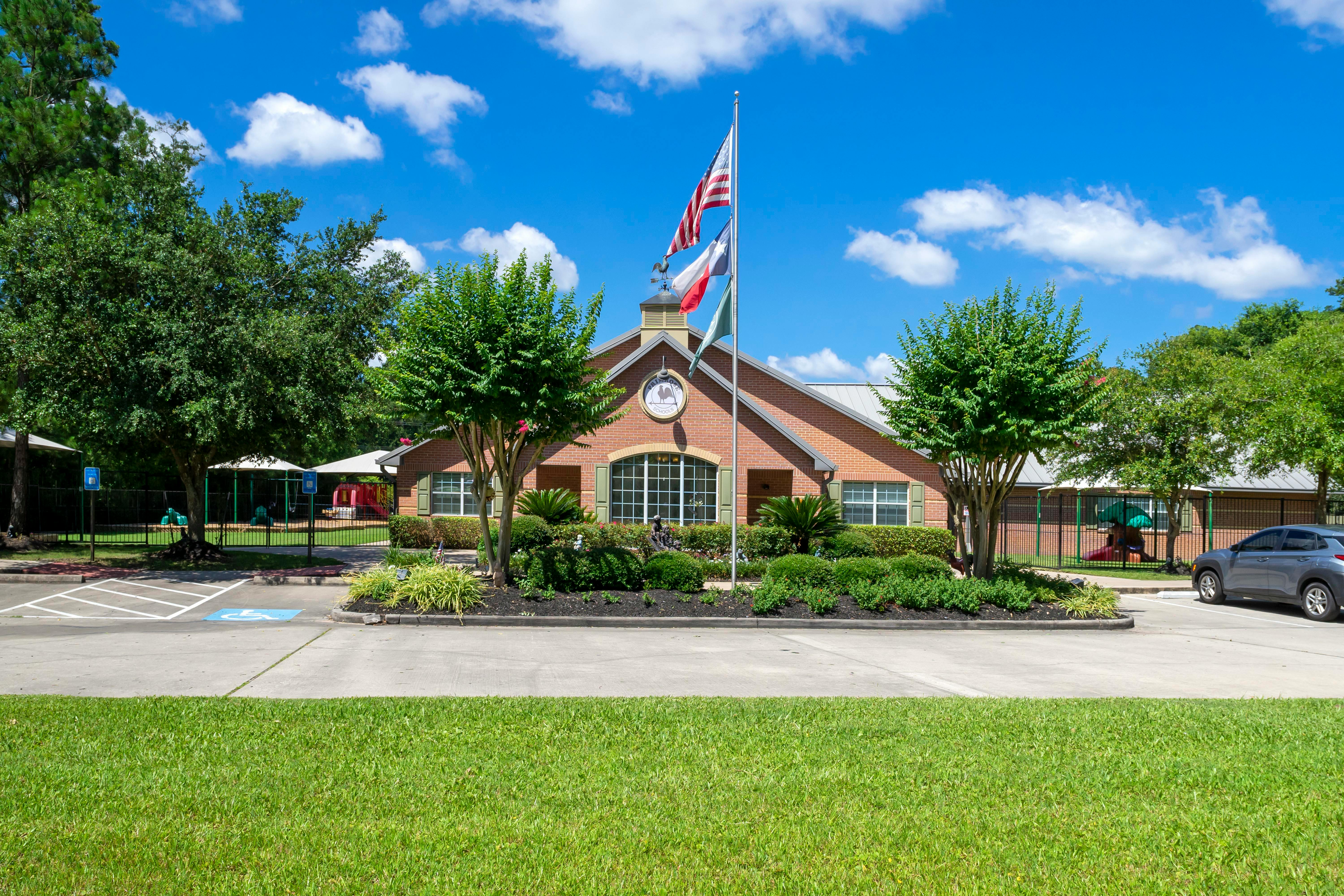 Brick building with a flagpole, landscaping, and an adjacent playground