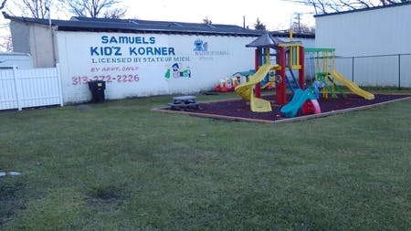 Playground with slides and climbing structures next to a building with text