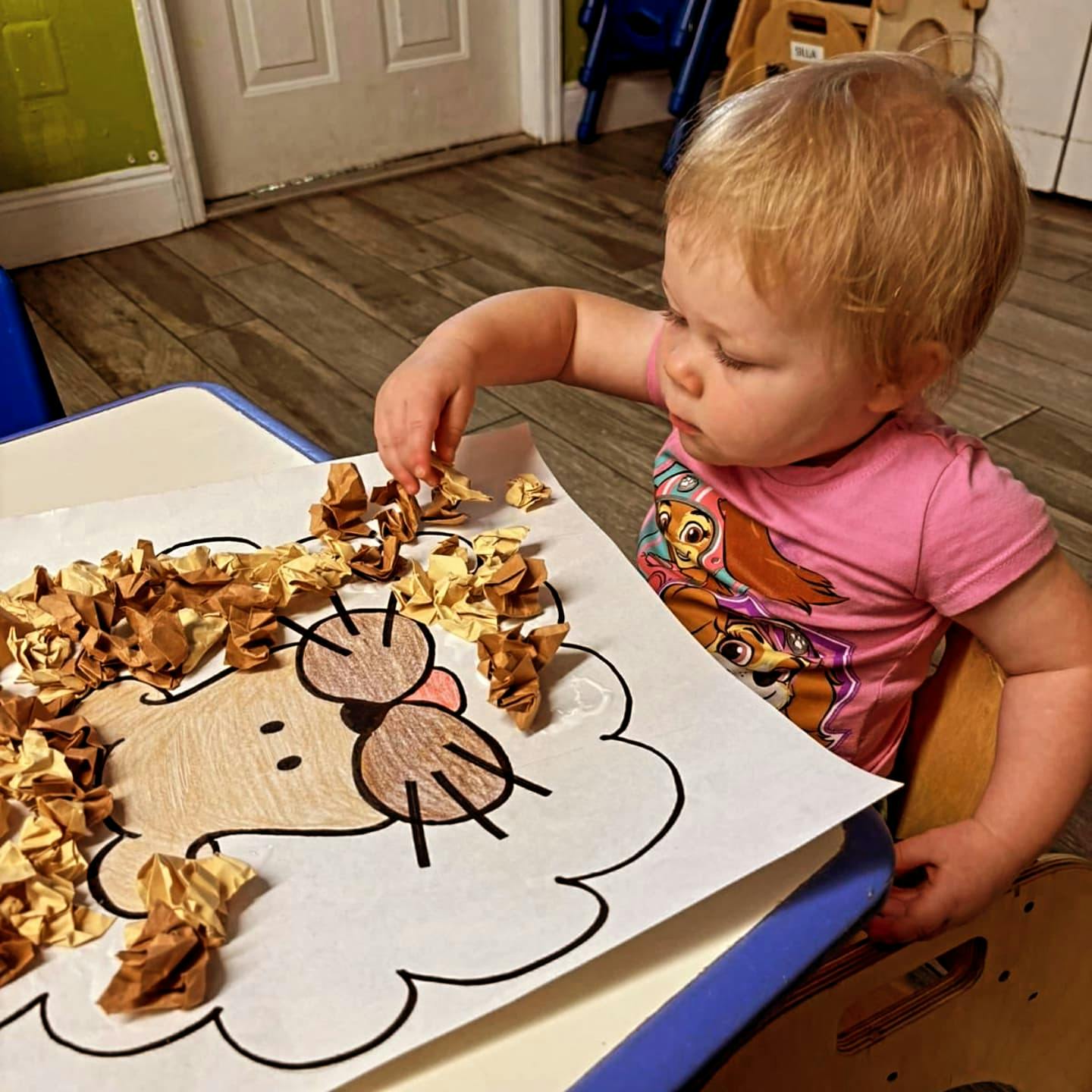 Child doing an art project with paper and crumpled paper pieces