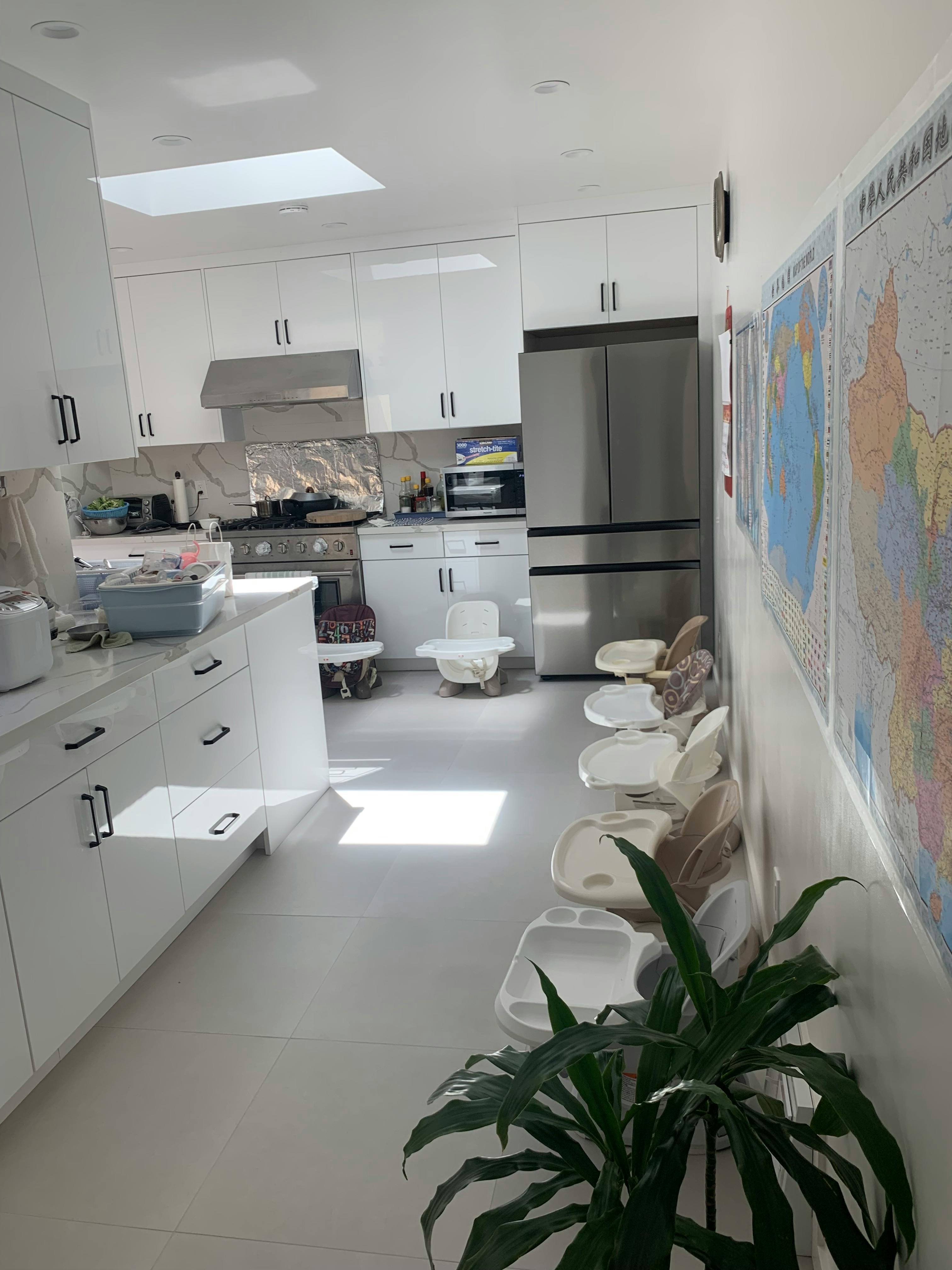 Kitchen with white cabinets, stainless steel appliances, and multiple high chairs